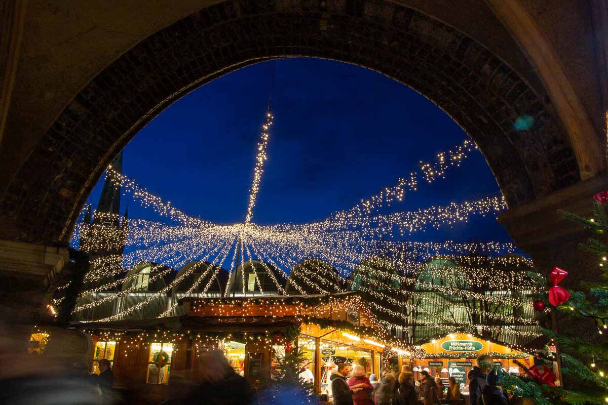 Blick durch einen Arkadenbogen auf das Lichterzelt aud dem Lübecker Weihnachtsmarkt