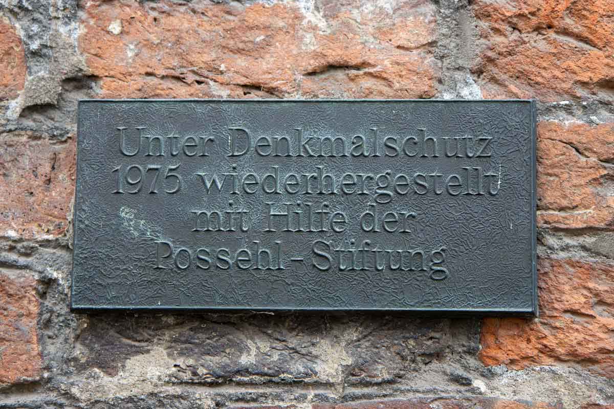 Plakette der Possehl-Stiftung mit Aufschrift: Unter Denkmalschutz wiederhergestellt mit Hilfe der Possehl-Stiftung